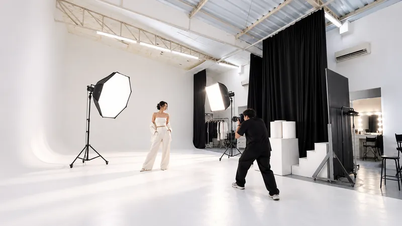 Ensaio de moda no Estúdio AB da Aclimação: modelo no fundo branco infinito, fotógrafo, softboxes, cortina preta e camarim ao fundo